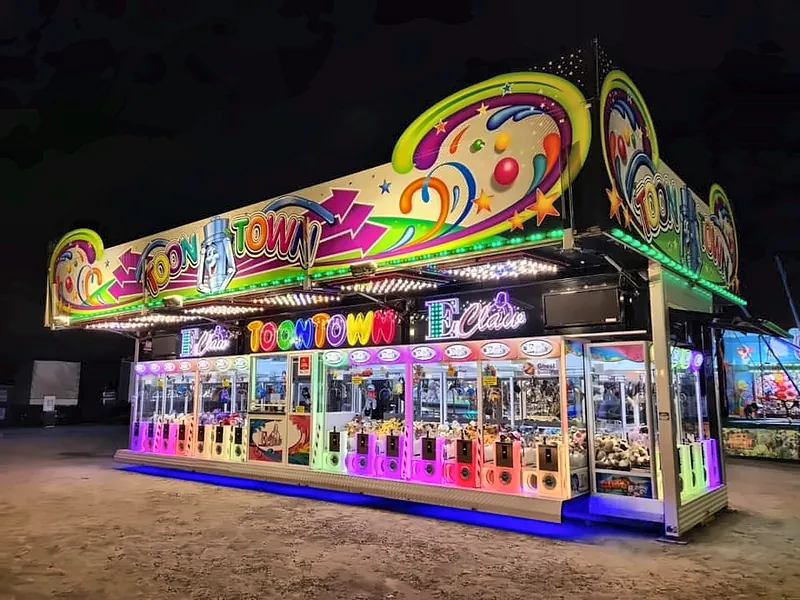 Toon Town nachts von schräg vorn: die Tiefe des Geschäfts mit Dach und Leuchtkästen.